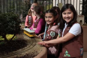 Girl scouts learning about model trolley car at the San Diego Model Railroad Museum