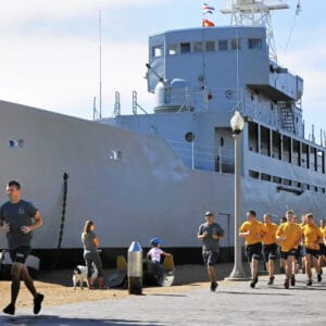 Navy Personnel Jog Past The Recruit, Nicknamed The “Neversail,” In San Diego It Is The Only Commissioned Ship In The Navy That Never Touched Water (Don Bartletti : Los Angeles Times)