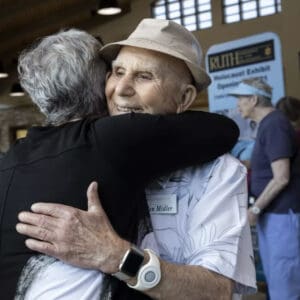 Sandra Scheller, Left, And Ben Midler Hug During A Tour Of A New Holocaust Remembrance Exhibit At Rancho San Diego Library
